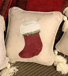 two pillows with christmas stockings on them and tassels