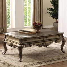 a living room with a coffee table and two vases on top of the tables