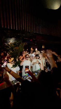 a group of people standing around each other in front of a crowd at a concert