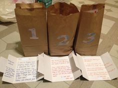 three brown paper bags with numbers on them sitting on the floor next to some papers