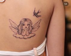 a woman with a tattoo on her back has a bird flying over her shoulder and there is a dove in the background