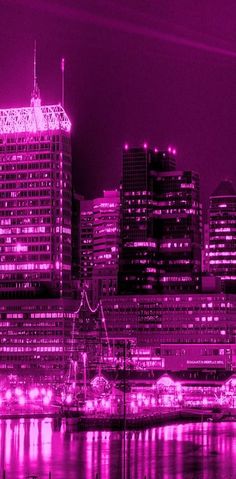 the city skyline is lit up in purple light