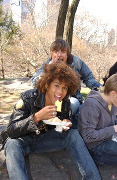 four people sitting on the ground eating food