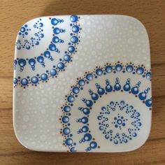 a decorative blue and white plate sitting on top of a wooden table