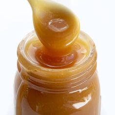 a jar filled with honey sitting on top of a table