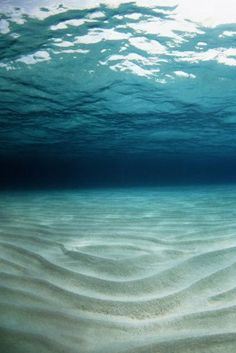 an underwater view of sand and water