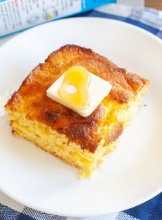 a piece of cake on a white plate with a blue checkered table cloth next to it