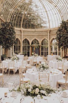 the inside of a building with tables and chairs set up for a formal function in front of large windows