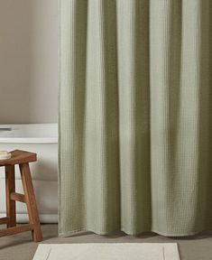 a bath room with a shower curtain and a rug on the floor in front of it