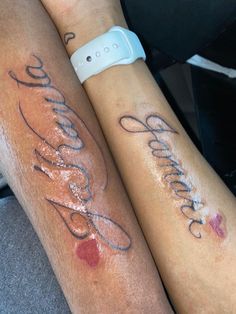 two people sitting next to each other with tattoos on their legs and armbands