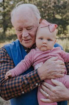 an older man holding a baby in his arms