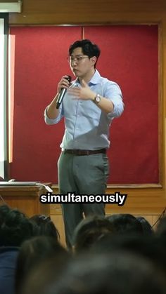 a man standing in front of a crowd holding a microphone