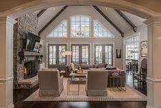 a living room filled with lots of furniture and a fire place in the middle of it