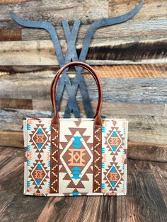 a brown and white handbag sitting on top of a wooden table next to a wall