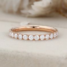 a rose gold wedding band with five round cut diamonds on the inside and outside of it