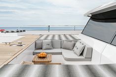 a couch sitting on top of a wooden floor next to a table with oranges