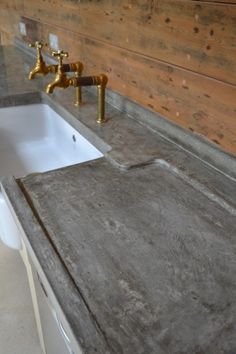 a white sink sitting under a faucet next to a wooden wall