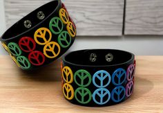 "Embrace the vibrant spirit of Rasta culture with this handmade leather bracelet, adorned with classic peace symbols in the iconic Rasta colors of red, yellow, and green. Each bracelet is crafted with love, symbolizing unity and the reggae lifestyle. Materials: High-quality, sustainable leather base Durable metal peace signs with enamel coating in Rasta colors Size: Adjustable strap to fit a variety of wrist sizes comfortably Features: Versatile unisex design for all genders Bold Rasta colors re Adjustable Multicolor Rave Wristband, Hippie Black Bracelets For Festivals, Black Hippie Bracelets For Festival, Retro Multicolor Bracelets As Gift, Multicolor Retro Bracelets For Gift, Retro Multicolor Bracelets For Gift, Multicolor Retro Bracelet As Gift, Multicolor Retro Bracelet For Gift, Handmade Multicolor Leather Bracelet Casual Style