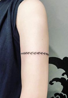 a woman's arm with an arrow tattoo on the left side of her arm