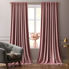 a living room with pink curtains and a chair