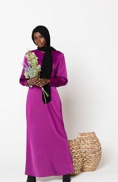 Invitation Accepted! The Fuschia Satin Long Sleeve Maxi Dress features a round neckline, buttons on the cuff, batwing sleeves, pleats on the chest, and sheath silhouette. The dress is fully lined. This soft and feminine texture and color gives the perfect level of modesty and elegance! Match it with one of our Hijab for the perfect look! Zip fastening Regular fit True to size Satin Lined Model is 5'10" wearing a size Small Feminine Texture, Satin Long Sleeve, Sleeve Maxi Dress, Long Sleeve Maxi, Maxi Wrap Dress, Off Black, Batwing Sleeve, Long Sleeve Maxi Dress, Round Neckline