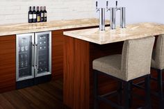 a kitchen with two bar stools next to a wine cooler