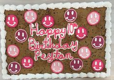 a birthday cake decorated with smiley face cookies