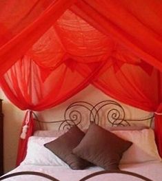 an image of a bed with red canopy over it