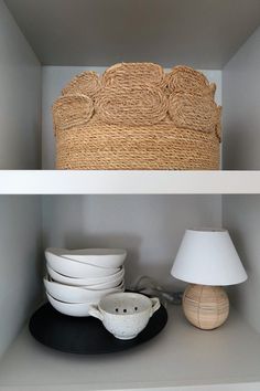 two shelves with bowls and plates on them