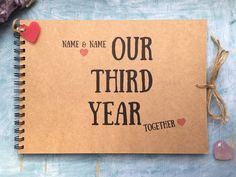 a brown notebook with the words, name and name our third year together on it