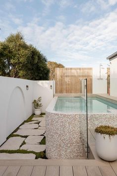 an outdoor swimming pool in the middle of a backyard with grass growing on the ground