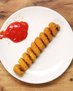 a white plate topped with fried food and ketchup