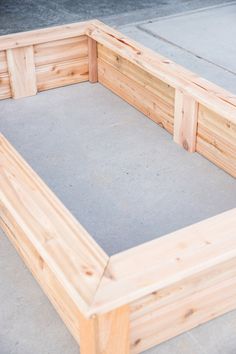 a wooden bed frame sitting on top of cement