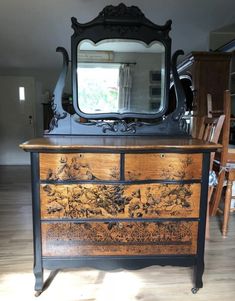 an old dresser with a mirror on top of it in the middle of a room