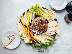 a platter filled with meat, vegetables and crackers