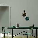 a green table and two chairs in a room with white walls, carpet and an open door