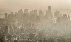 an aerial view of a city with skyscrapers and fog in the air, taken from above