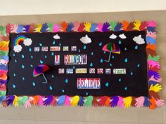 a bulletin board with handprints and umbrellas on the blackboard that says rainbow