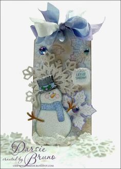 a card with a snowman on the front and blue ribbon around it's neck