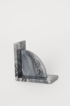 a marble bookend with an irregular shape on the front and side, against a white background