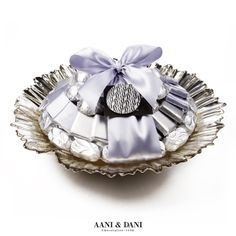 a decorative silver plate with a bow on it