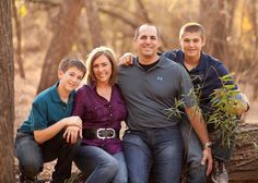 a family posing for a photo in the woods