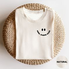 a white t - shirt with a smiley face drawn on it