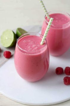 two glasses of raspberry smoothie on a plate