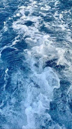 the back end of a boat traveling through the blue ocean with white foamy water