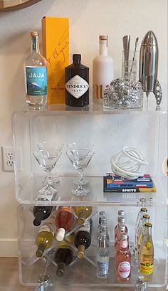 a clear shelf filled with bottles and glasses