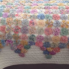 a crocheted flower quilt is displayed on a bed