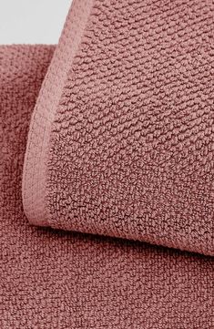 a close up shot of the textured fabric on a bed sheet in dusty pink