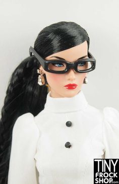 a close up of a doll wearing glasses and a white dress with black hair,