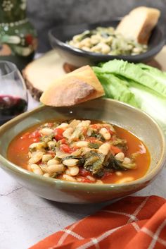 a white bowl filled with soup next to bread